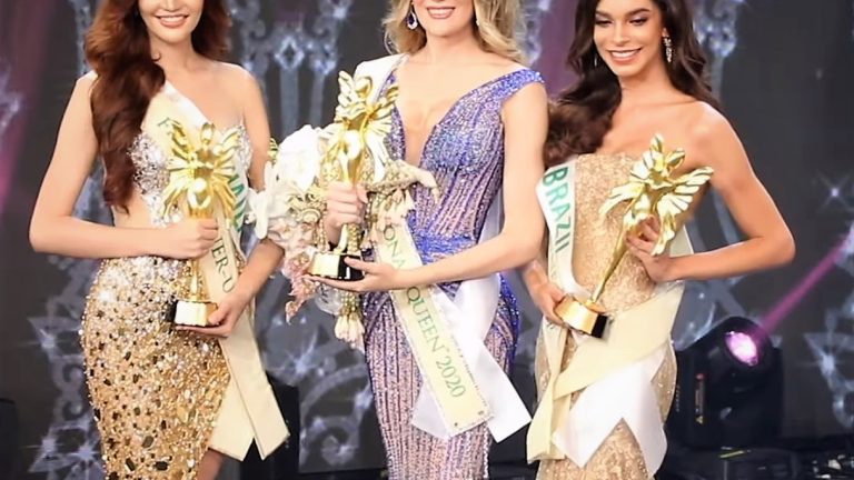 The three finalists of Miss International Queen 2020 on stage in evening gowns, holding trophies